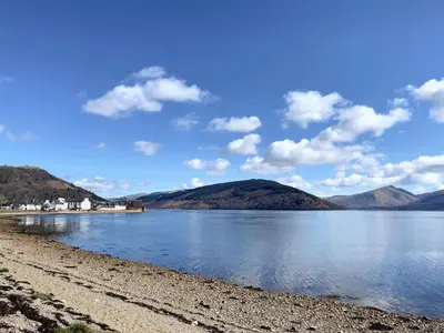 a view of a lake with mountains in the background at Newton Cottage North in Inveraray