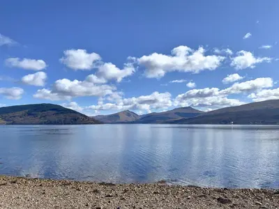 a view of a lake with mountains in the background at Newton Cottage North in Inveraray