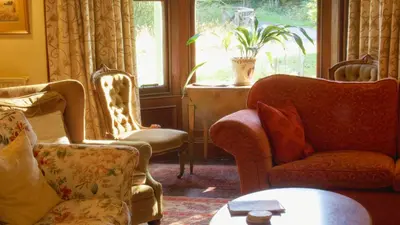 a living room with chairs and a table and a window at Lagafater Lodge in Glenwhilly