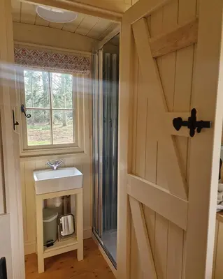 a bathroom door with a sink and a window at Trigony Hotel and Garden Spa in Closeburn