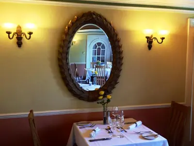 a dining room with a table with a mirror at Trigony Hotel and Garden Spa in Closeburn