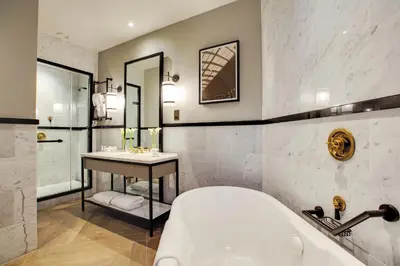 a bathroom with a tub and a sink at voco Grand Central Glasgow by IHG in Glasgow