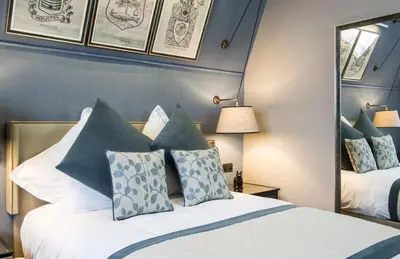 a bedroom with two beds and a mirror at voco Grand Central Glasgow by IHG in Glasgow