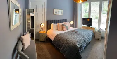 a bedroom with a bed and a television in it at Haylie Hotel in Largs