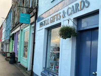 a store with a sign on the side of a building at The waterfront in Tarbert