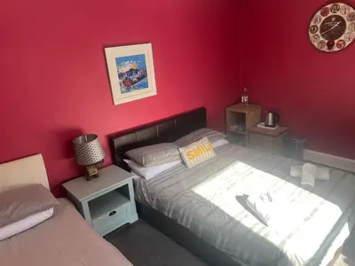 a bedroom with a bed and a red wall at The waterfront in Tarbert