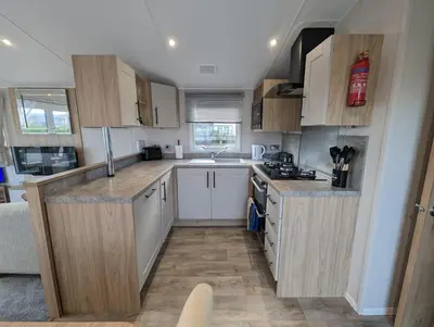 a small kitchen with white cabinets and wooden counters at The Manor Sea View 8 in Dunoon