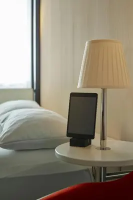 a lamp on a table next to a bed at citizenM Glasgow in Glasgow