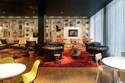 a living room with couches and tables and chairs at citizenM Glasgow in Glasgow