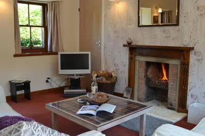 a living room with a fireplace and a coffee table at The Steading at Barmore in Tarbert