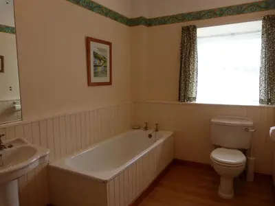 a bathroom with a tub and a toilet and a sink at The Steading at Barmore in Tarbert