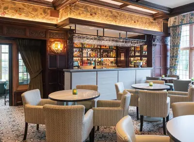 a restaurant with tables and chairs and a bar at Piersland House in Troon