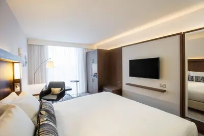 a hotel room with a bed and a tv at Courtyard by Marriott Edinburgh West in Edinburgh