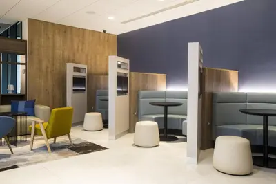 a waiting room with tables and chairs at Courtyard by Marriott Edinburgh West in Edinburgh