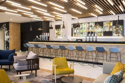 a bar with chairs and a bar counter at Courtyard by Marriott Edinburgh West in Edinburgh