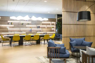 a waiting room with yellow chairs and a table at Courtyard by Marriott Edinburgh West in Edinburgh