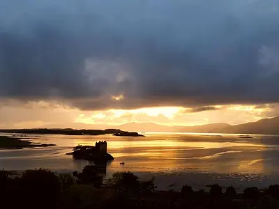 a sunset on a lake with a boat in the water at Appin Bay View in Appin