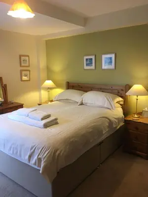 a bedroom with a large white bed with two lamps at 1/5 Lismore House in Oban