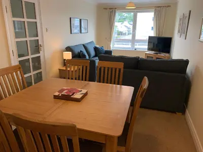 a living room with a table and a couch at 1/5 Lismore House in Oban