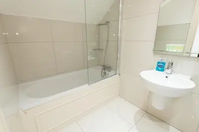 a white bathroom with a sink and a shower at Royal Princes Suites in Edinburgh