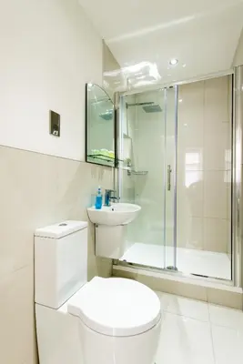 a white bathroom with a toilet and a shower at Royal Princes Suites in Edinburgh