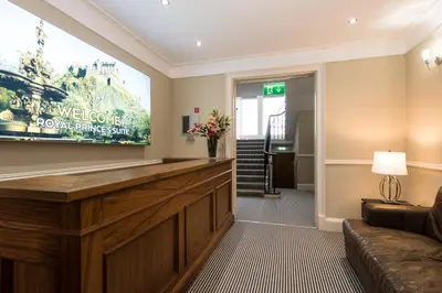 a hotel lobby with a welcome sign on the wall at Royal Princes Suites in Edinburgh