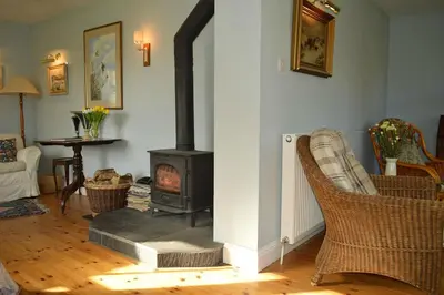 a living room with a wood stove in a room at Shelduck Cottage in Feorlean