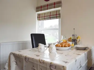 a table with a bowl of bread and a bowl of fruit at Sandhaven in Culross