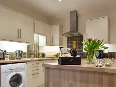 a kitchen with white cabinets and a dishwasher at Nether Cottage in Saline