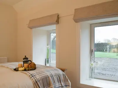 a bedroom with a bed and a window at Nether Cottage in Saline
