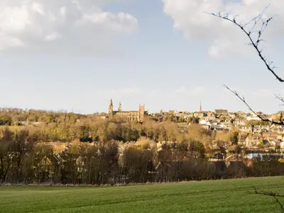 a town on a hill with a green field at Kinneddar Cottage in Saline