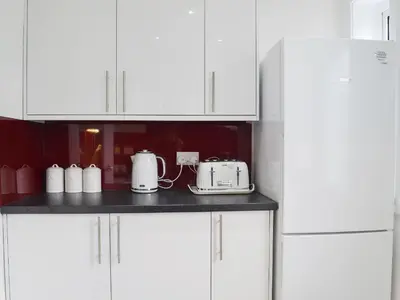a kitchen with white cabinets and white appliances at Rocky Mountain View in Ballachulish