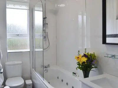 a white bathroom with a tub and a toilet and a sink at Rocky Mountain View in Ballachulish