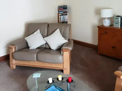 a living room with a couch and a table at Caroch Cottage in Comrie
