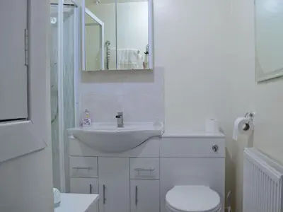a white bathroom with a sink and a toilet at Caroch Cottage in Comrie