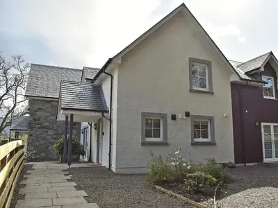 a white house with a fence in front of it at Casa Duran in Killin