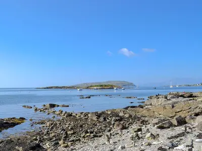 a rocky beach with boats in the water at Thornbank in Millport