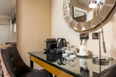 a vanity with a mirror and a chair in a room at The Kylestrome in Ayr