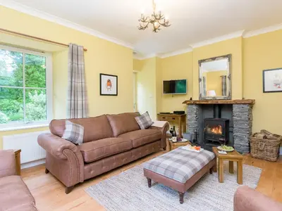 a living room with a couch and a fireplace at Grace's Cottage in Port of Menteith