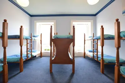 a room with four bunk beds and two windows at Oban Backpackers in Oban