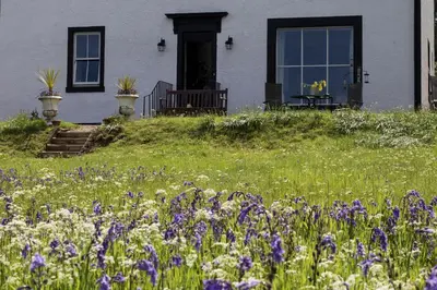 a field of flowers in front of a house at Pennygate Lodge in Craignure