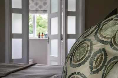 a pillow sitting on a bed next to a window at Pennygate Lodge in Craignure