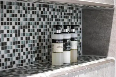 three deodorant bottles sitting on a shelf in a bathroom at Pennygate Lodge in Craignure