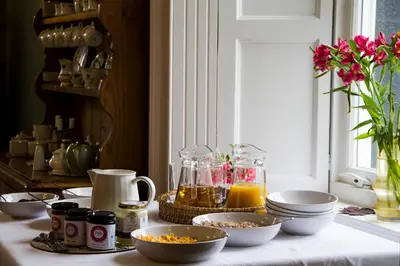 a table with bowls of food on a table with a window at Pennygate Lodge in Craignure
