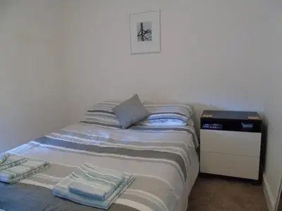 a bedroom with a bed with two towels on it at Snug - Krayr Apartment in Helensburgh