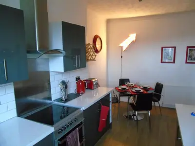 a kitchen with a table and a counter top at Snug - Krayr Apartment in Helensburgh