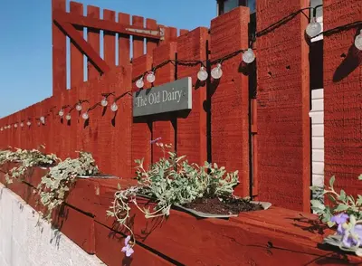 a red brick wall with a sign that reads this old divide at The Old Dairy in Brodick