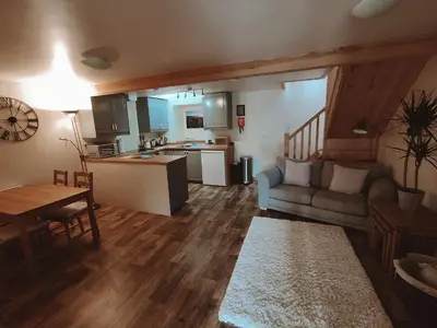 a living room and kitchen with a couch and a table at The Old Dairy in Brodick