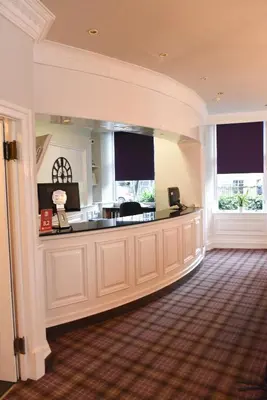a large room with a kitchen with two windows at Sandyford Hotel in Glasgow