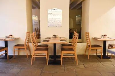 a dining room with wooden tables and chairs at Sandyford Hotel in Glasgow